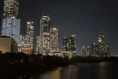Lit tower blocks reflected in a dark river at night