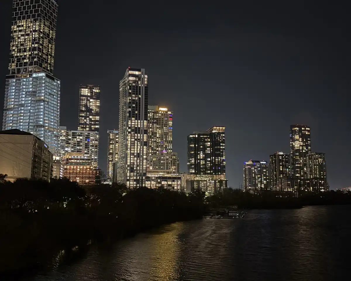 Lit tower blocks reflected in a dark river at night